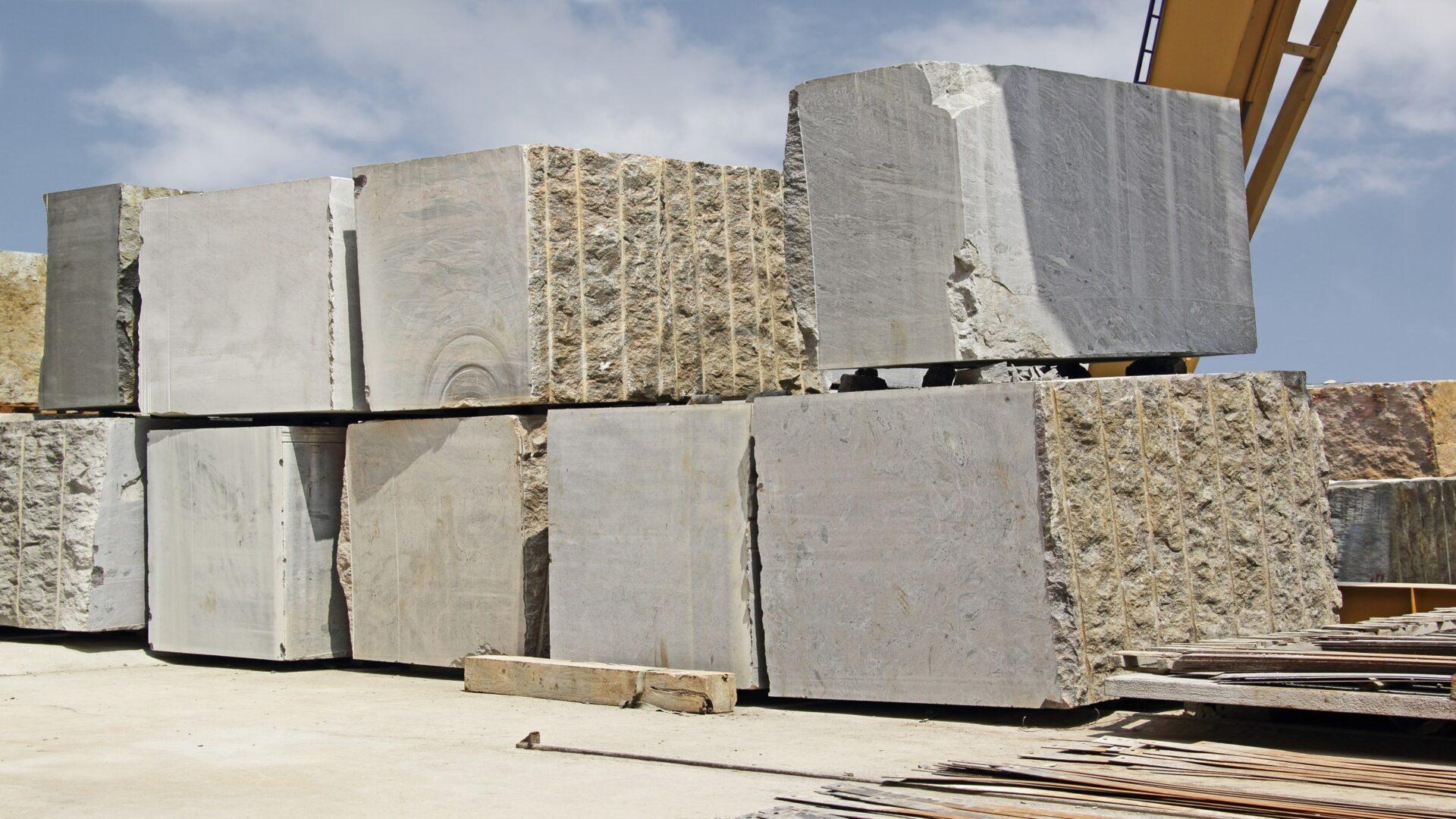 Huge Indian granite blocks stacked in a stone processing factory for cutting and polishing into flooring slabs used in building construction.